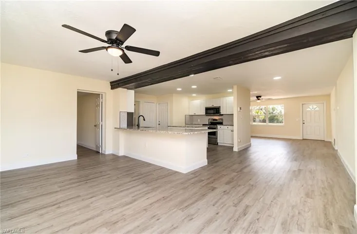 Kitchen featuring open floor plan, a ceiling fan, white cabinetry, recessed lighting, and a peninsula