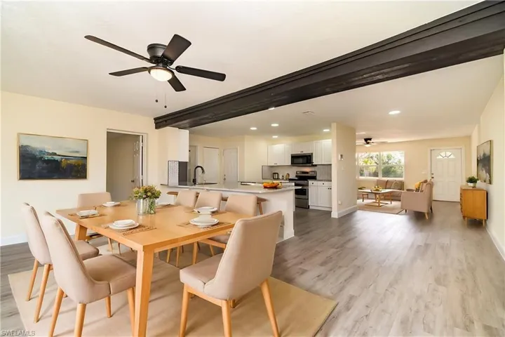 Dining space with ceiling fan, light wood-style flooring, recessed lighting, and beamed ceiling