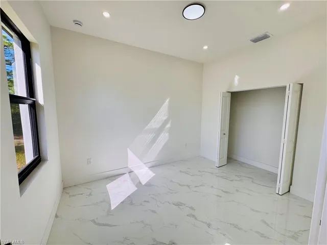 Unfurnished bedroom featuring light marble finish flooring and recessed lighting