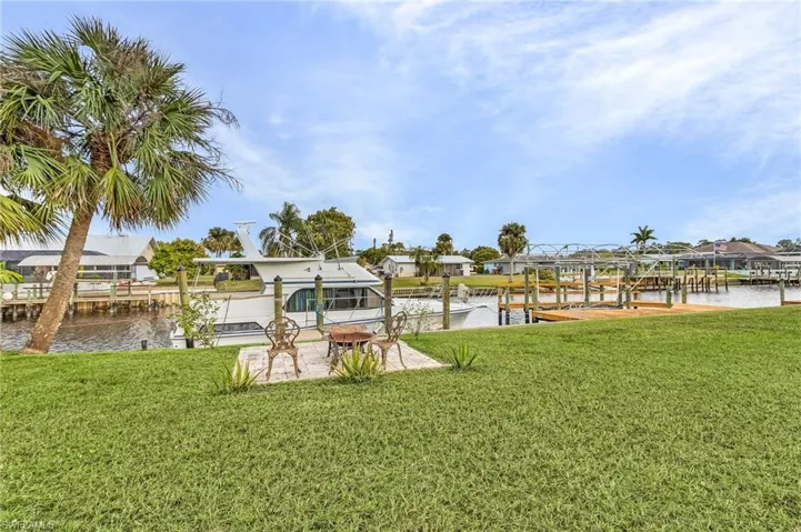 Dock area featuring a water view, a yard, and a patio area