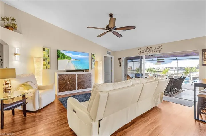 Living room featuring lofted ceiling, hardwood / wood-style floors, and ceiling fan