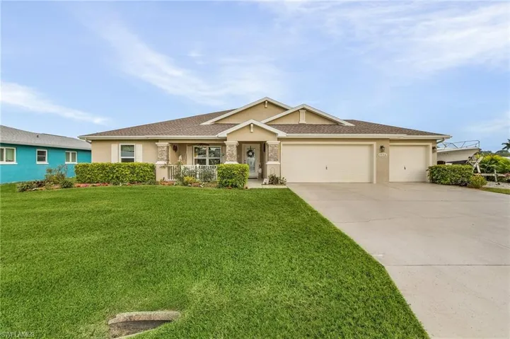 View of front of home featuring a garage, covered porch, and a front lawn