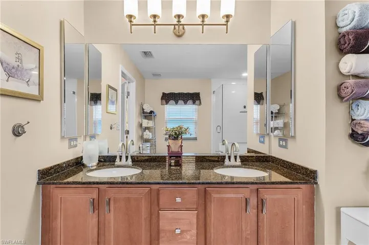Bathroom featuring vanity, a shower with door, and toilet