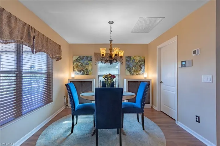 Dining area with plenty of natural light, dark hardwood / wood-style floors, and an inviting chandelier