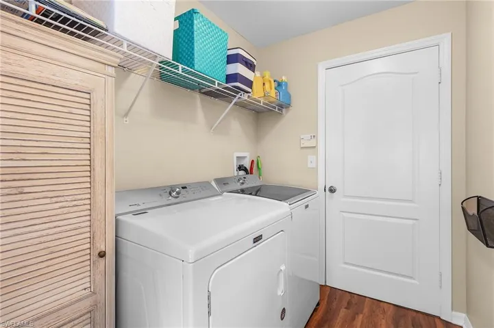 Laundry area featuring dark wood-type flooring and washing machine and dryer