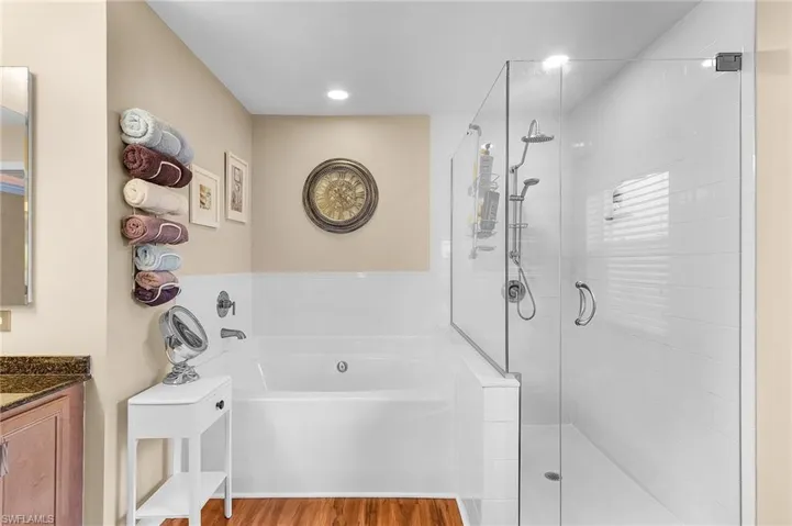 Bathroom with vanity, separate shower and tub, and hardwood / wood-style floors