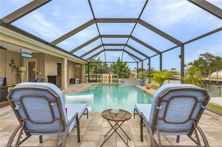 View of pool with glass enclosure and a patio area