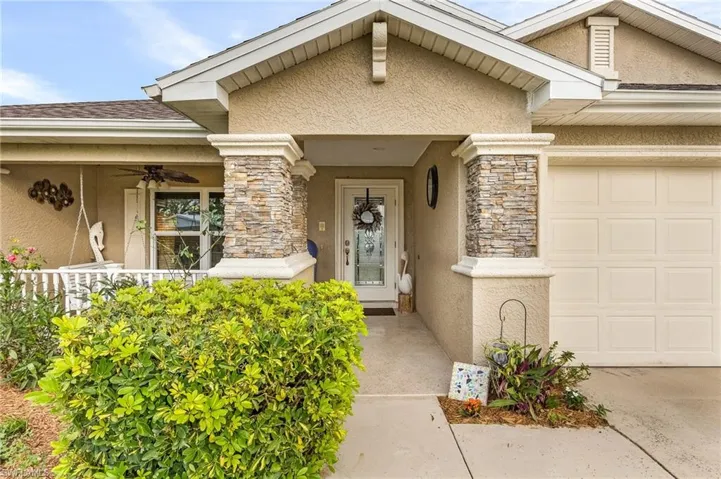 Property entrance featuring a garage and covered porch