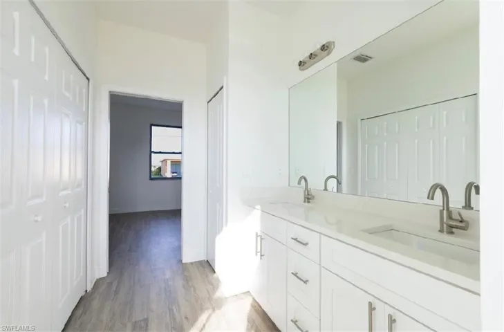 Bathroom featuring dual bowl vanity and hardwood / wood-style flooring