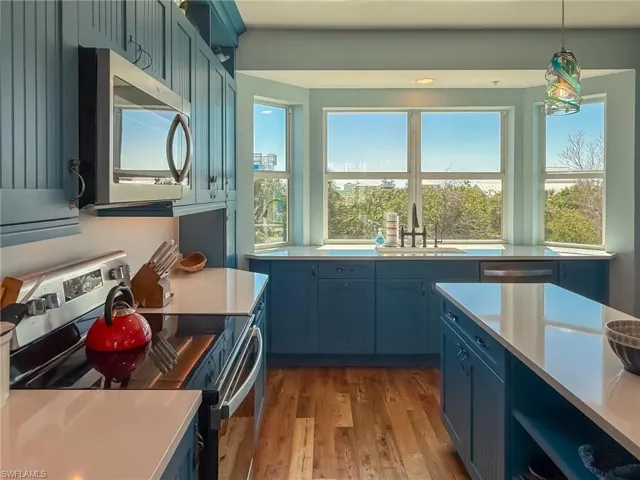 Kitchen with a sink, light countertops, blue cabinets, and stainless steel appliances