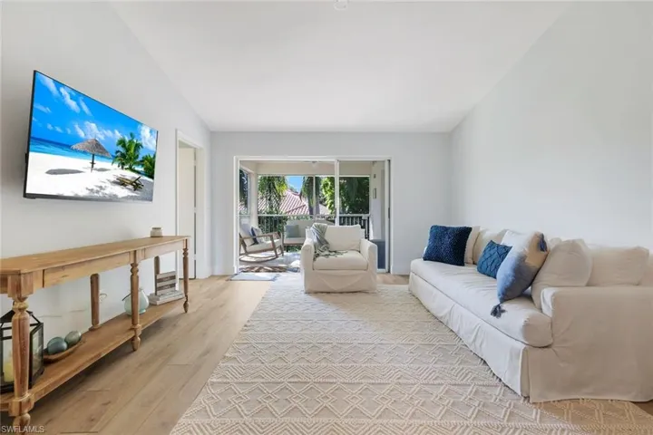 Living room featuring light wood-style flooring and vaulted ceiling