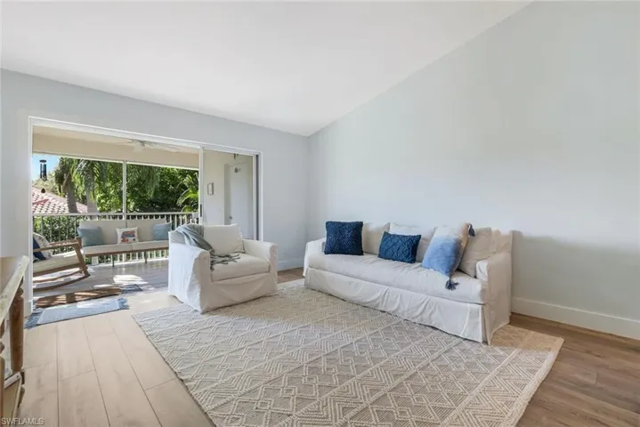 Living room with light wood-style floors and lofted ceiling
