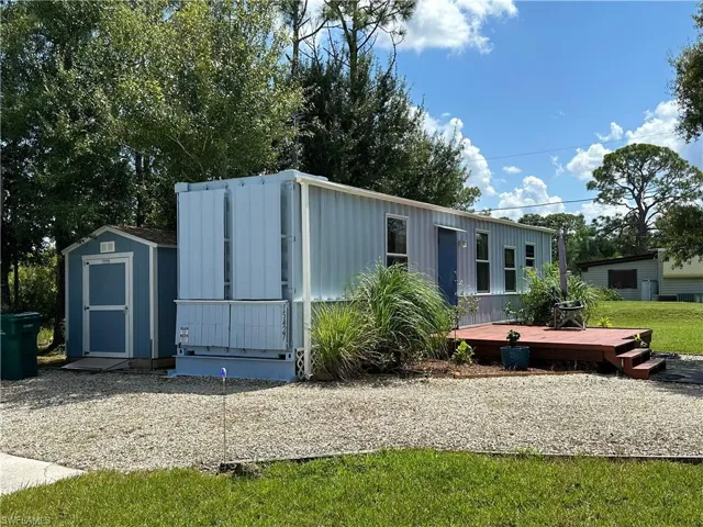 View of front of home featuring a storage shed, board and batten siding, and a front yard