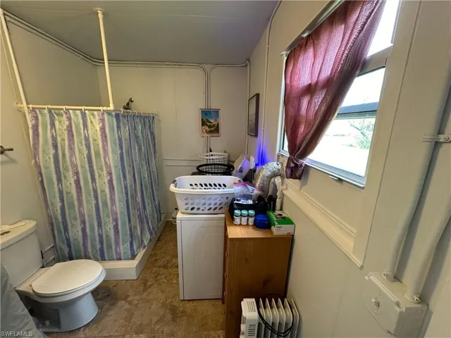 Full bath featuring a shower stall and a decorative wall