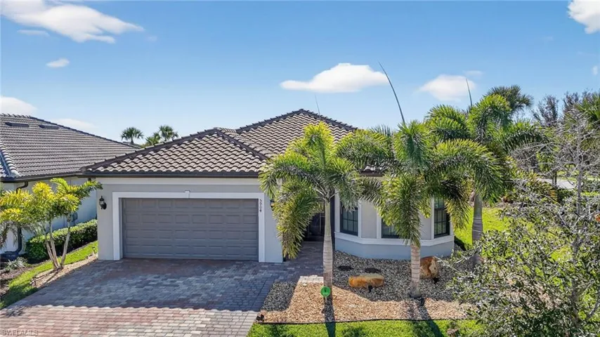 View of front of home featuring stucco siding, decorative driveway, an attached garage, and a tile roof