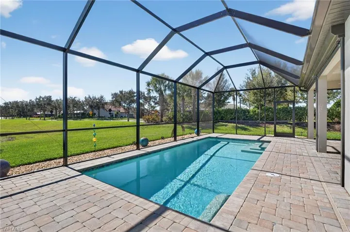 Outdoor pool with a lanai, a yard, a sunroom, and a patio area