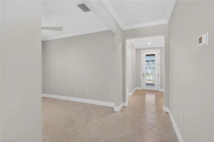 Corridor with ornamental molding and light tile patterned floors