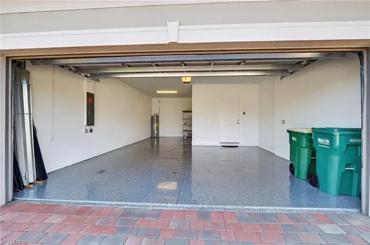 Garage featuring electric panel and electric water heater