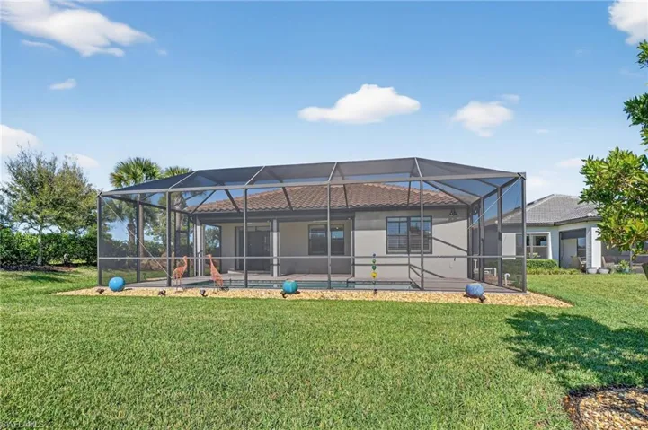 Back of property featuring a sunroom, a lanai, a pool, and a yard