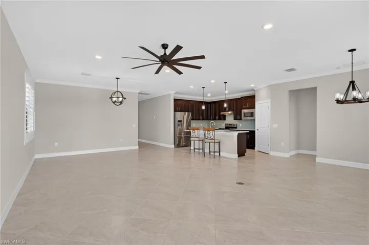 Unfurnished living room featuring a chandelier, recessed lighting, crown molding, and ceiling fan