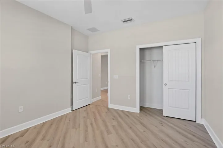 Unfurnished bedroom featuring a closet, light wood finished floors, and ceiling fan