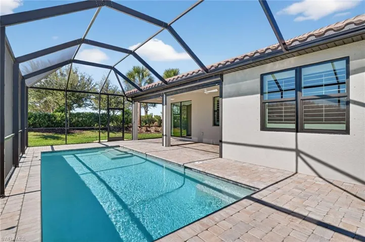 Outdoor pool featuring a patio, a sunroom, and a lanai
