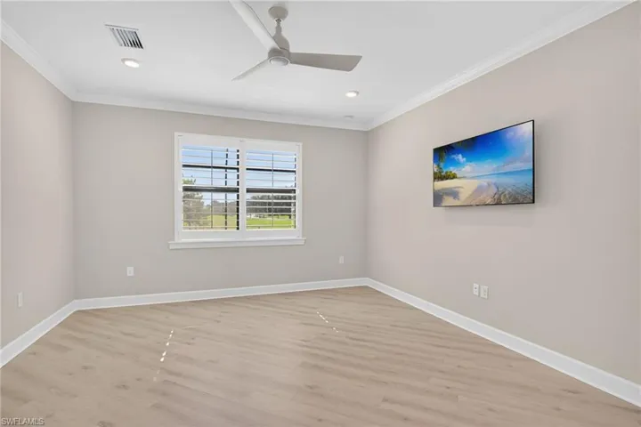 Spare room with crown molding, light wood-style flooring, ceiling fan, and recessed lighting