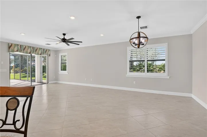 Empty room featuring a chandelier, recessed lighting, ornamental molding, a ceiling fan, and light tile patterned floors