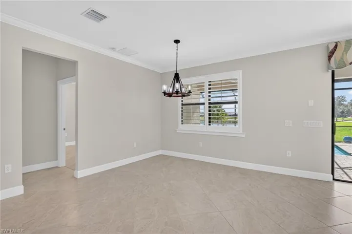 Unfurnished room with crown molding and a chandelier