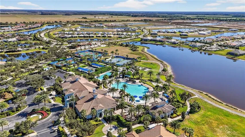 Aerial view of property and surrounding area with a large body of water and nearby suburban area