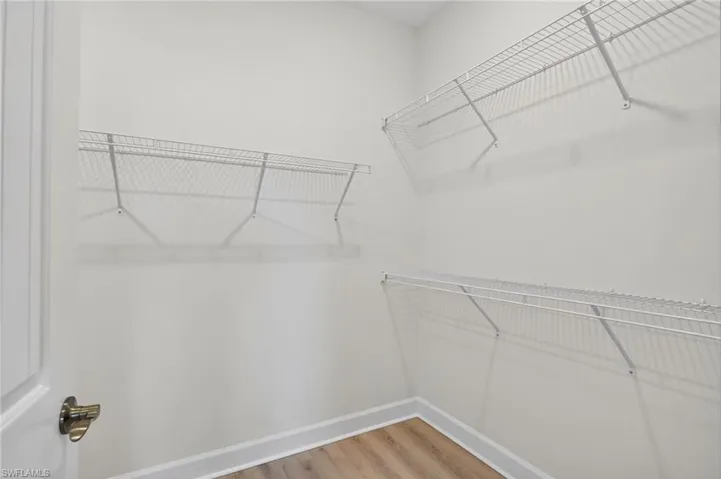 Walk in closet with light wood-type flooring