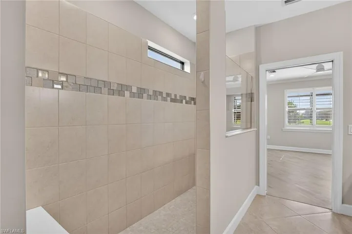 Full bathroom with walk in shower and tile patterned flooring