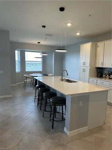 Kitchen with sink, a spacious island, and white cabinets.