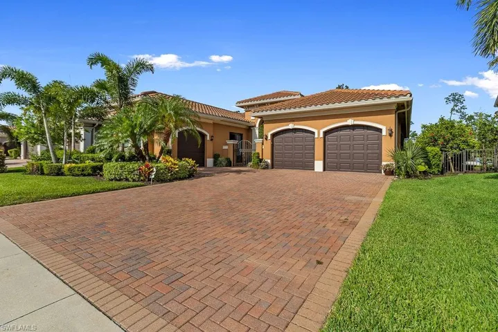 Mediterranean / spanish-style home with a garage and a front lawn