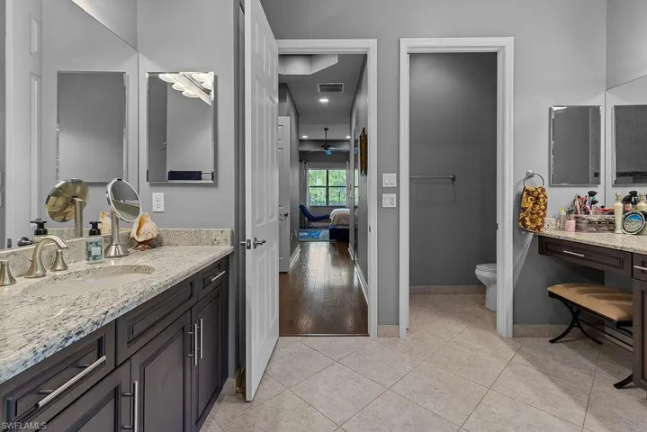 Bathroom featuring tile patterned flooring, vanity, toilet, and ceiling fan