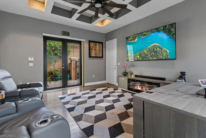 Living room with ceiling fan, french doors, coffered ceiling, light hardwood / wood-style flooring, and beamed ceiling