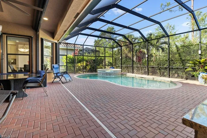 View of pool with a patio area, a lanai, and an in ground hot tub