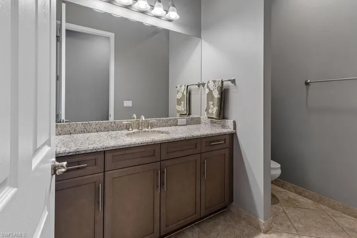 Bathroom featuring tile patterned flooring, vanity, and toilet