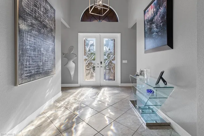 Foyer featuring french doors and light tile patterned floors