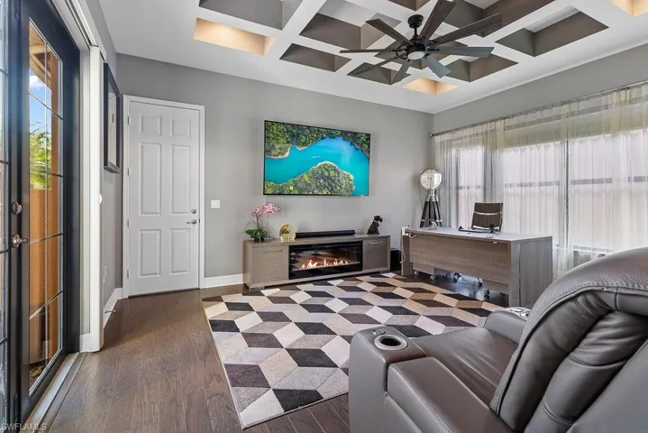 Living room with beamed ceiling, ceiling fan, dark wood-type flooring, and coffered ceiling
