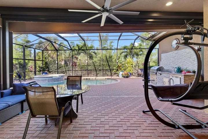 View of patio / terrace with ceiling fan, area for grilling, a lanai, and grilling area