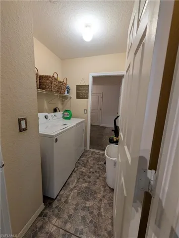 Dedicated utility space featuring patterned floor tile, a built-in wire shelf, and a panel door