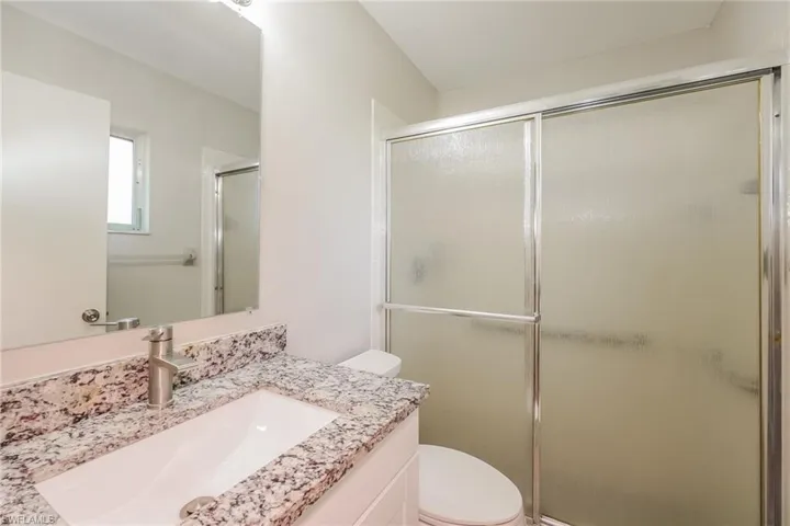 Bathroom with walk in shower, vanity, and toilet