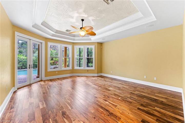 First floor master bedroom with set of French doors leading to the pool spa and lanai area