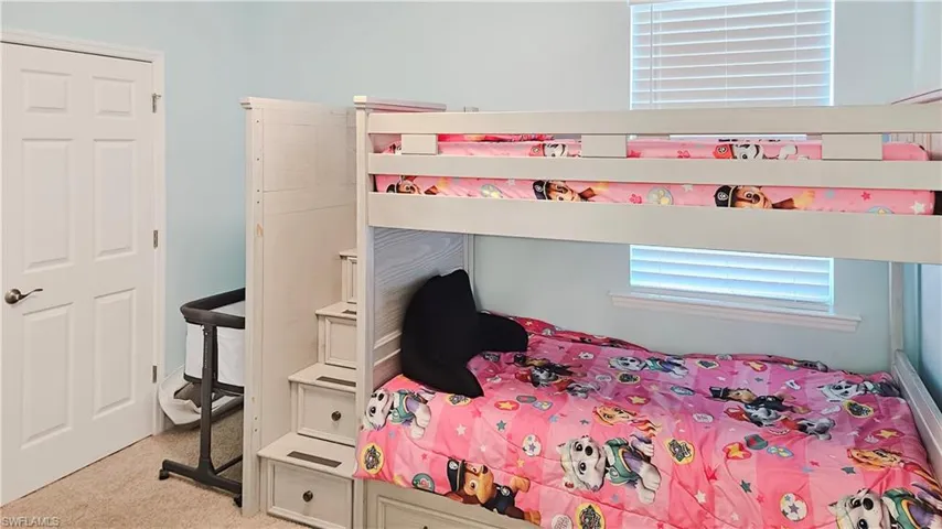 Bedroom featuring light colored carpet