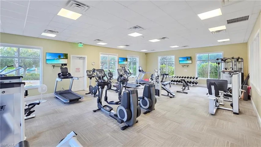 Workout area with a paneled ceiling and light carpet