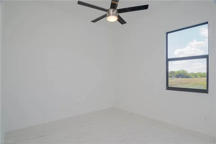 Unfurnished room featuring marble finish floor and baseboards
