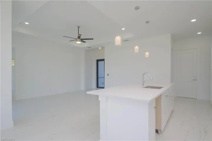 Kitchen featuring pendant lighting, marble finish floor, a center island with sink, recessed lighting, and a sink