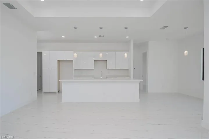 Kitchen featuring light countertops, modern cabinets, a sink, and white cabinets