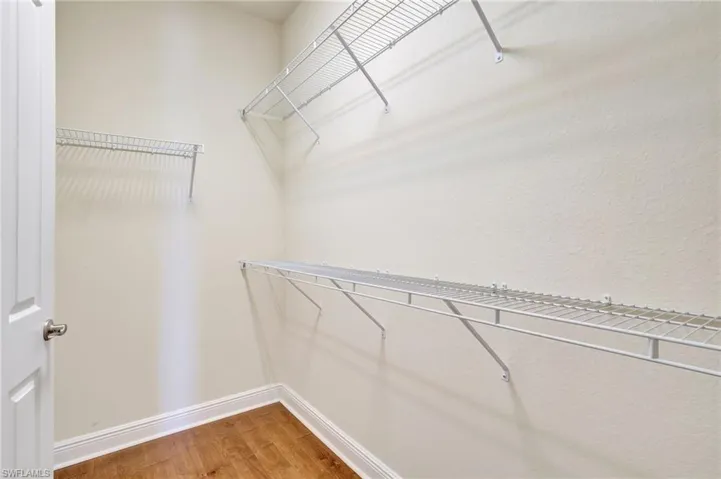 Spacious closet with hardwood / wood-style flooring
